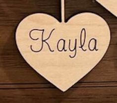 two wooden hearts with the word kayla hanging from them