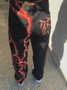 a person wearing black pants with lightning printed on them