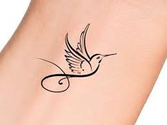 a small tattoo on the foot of a woman's foot with a bird flying above it