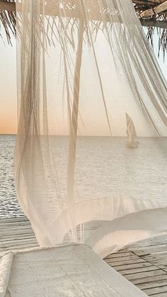 a sailboat is in the water under a gazebo with mosquito netting over it