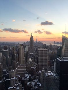 the sun is setting over new york's skyline as seen from top of the rock