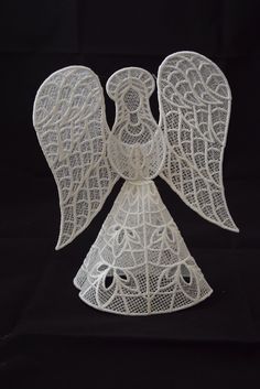 an angel made out of white lace on a black background