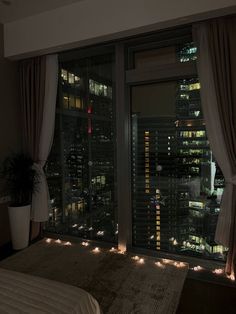 a bedroom with a view of the city at night