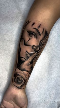 a woman's arm with a black and white tattoo design on the left forearm