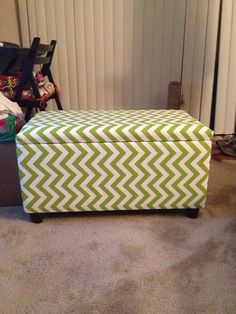 a green and white box sitting on top of a carpeted floor next to a radiator