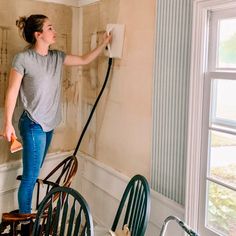 a woman is painting the walls in an old house with paint rollers and a blow dryer