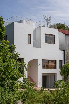 a large white house surrounded by trees and bushes