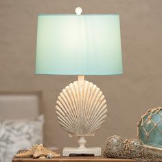 a lamp that is sitting on top of a table next to some shells and other items