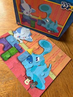 an elephant and giraffe puzzle on a wooden table