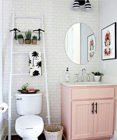 a white toilet sitting under a bathroom mirror next to a sink and bathtub in a bathroom