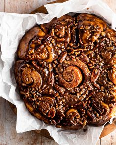 a chocolate bundt cake with pecans and nuts in it on a wooden table