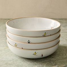 four white bowls with skiers painted on them