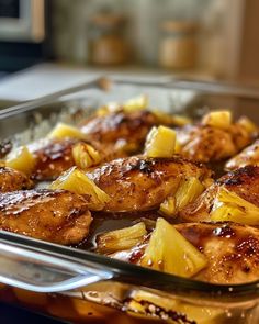 chicken and pineapples in a glass dish ready to be cooked on the stove