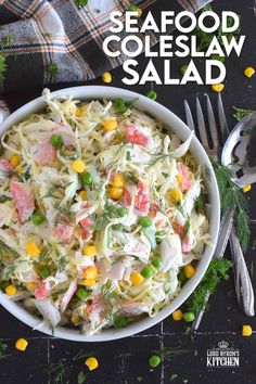 a bowl filled with coleslaw salad next to silverware