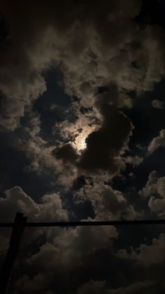 the sun is shining through the clouds in the night sky, as seen from an electric wire