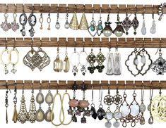 an assortment of earrings hanging on a wooden rack