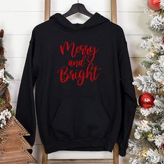 Merry and Bright Christmas Shirt for the holidays. This design is available in three styles including Christmas Sweatshirt, Christmas Hoodie and Christmas Long Sleeved TShirt. These Christmas shirts are made to order, choose from available print colors to get just the look you are wanting, including glitter options. All customizations are done in-house from Frisco, Texas.In order to provide quick turnaround, we source from four different top clothing brands. If you are needing a specific brand, Christmas Hoodie With Letter Print And Crew Neck, Christmas Cotton Hoodie With Letter Print, Holiday Letter Print Sweatshirt, Graphic Print Hoodie As A Winter Gift, Graphic Print Winter Hoodie As Gift, Graphic Print Hoodie As Winter Gift, Graphic Print Hoodie Winter Gift, Black Christmas Sweatshirt, Top Clothing Brands