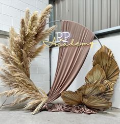 an arrangement of dried flowers and plants in front of a building