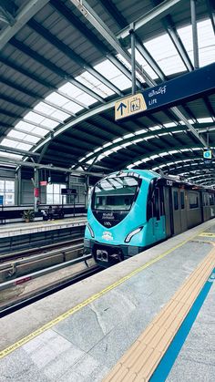 a blue train is parked at the station