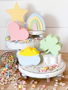 a table topped with lots of different types of food next to a rainbow shaped sign