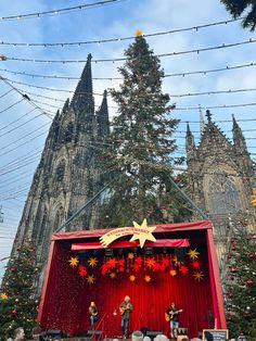 people are standing on stage in front of a christmas tree