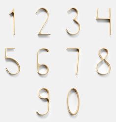 gold numbers and numerals are arranged on a white surface, with one number in the middle