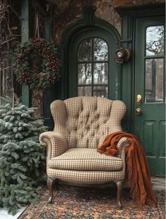 a chair sitting in front of a green door with a christmas tree next to it