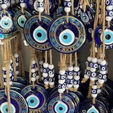 blue evil eye plates hanging from strings with ropes in front of them and eyes painted on them