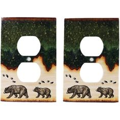 two light switch covers with bears and trees painted on the front, one is brown