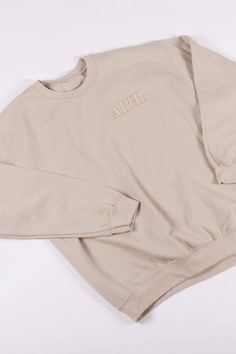 an open sweatshirt with the word ape written on it in gold foil and sits on a white surface