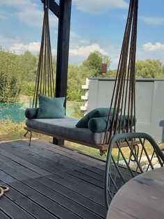 a swing chair sitting on top of a wooden deck