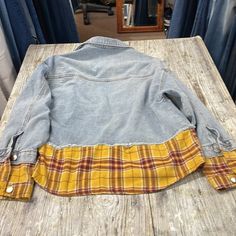 a denim jacket sitting on top of a wooden table