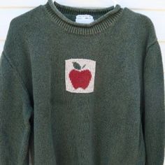 a green sweater with an apple on it