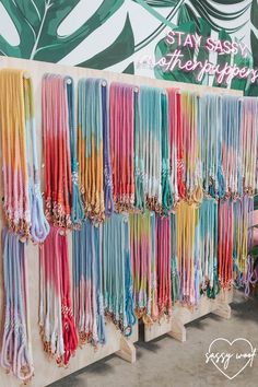 there are many different colored ties hanging on the wall in front of a sign that says stay safe and shop happy