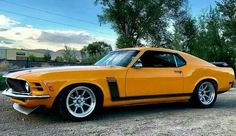 an orange muscle car parked in a parking lot