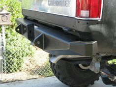 the rear bumper of a truck parked in front of a chain link fence