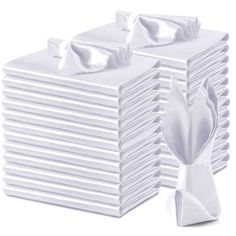 a stack of white folded napkins on top of each other