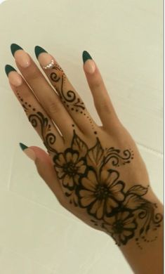 a woman's hand with henna tattoos on it