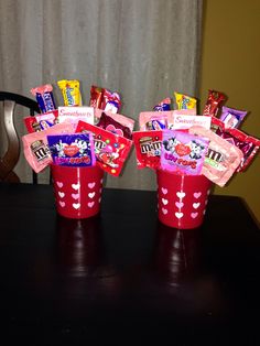 two red cups filled with candy sitting on top of a table