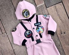 a pink baby romper with patches on it