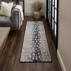 a living room with hardwood floors and a rug on the floor next to a couch