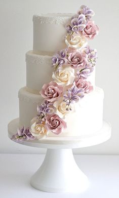 a three tiered wedding cake with flowers on it