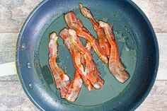 bacon is being cooked in a frying pan