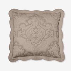 a beige pillow with an intricate design on the front and back, sitting on a white surface