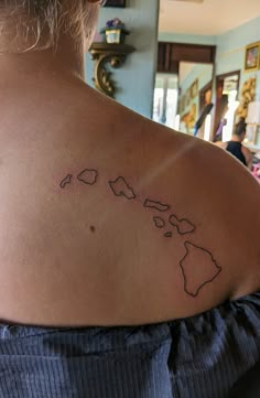 a woman with a tattoo on her shoulder that has the world map drawn on it