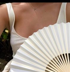 a woman holding a white fan in her hand