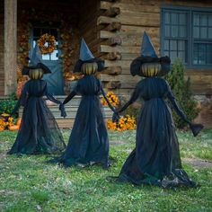 three black witches holding hands in front of a log cabin