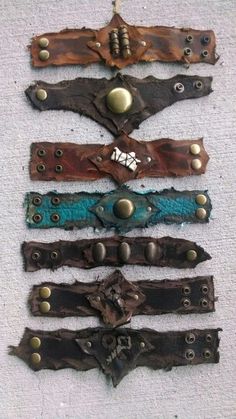 five leather bracelets with metal buttons and rivets on the ends, all in different colors