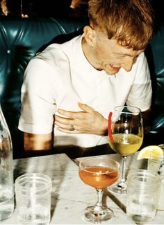 a man sitting at a table with glasses and bottles