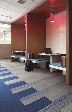 an empty room with benches and laptops on them